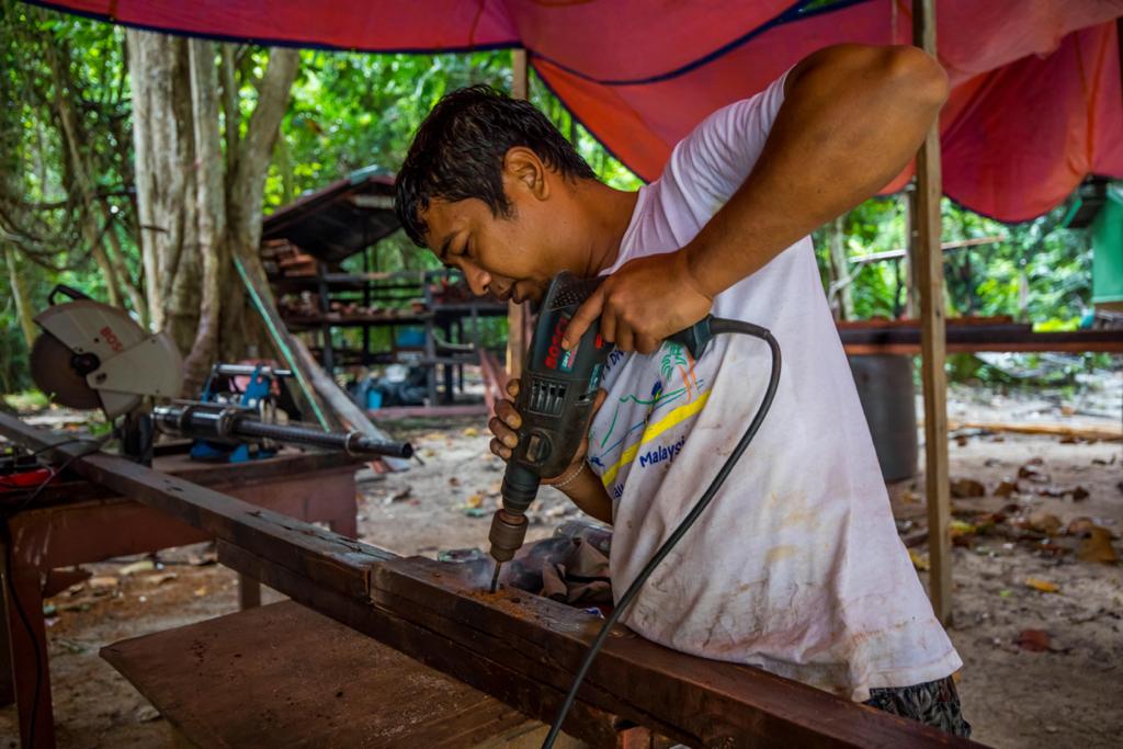 man drilling a wooden plank